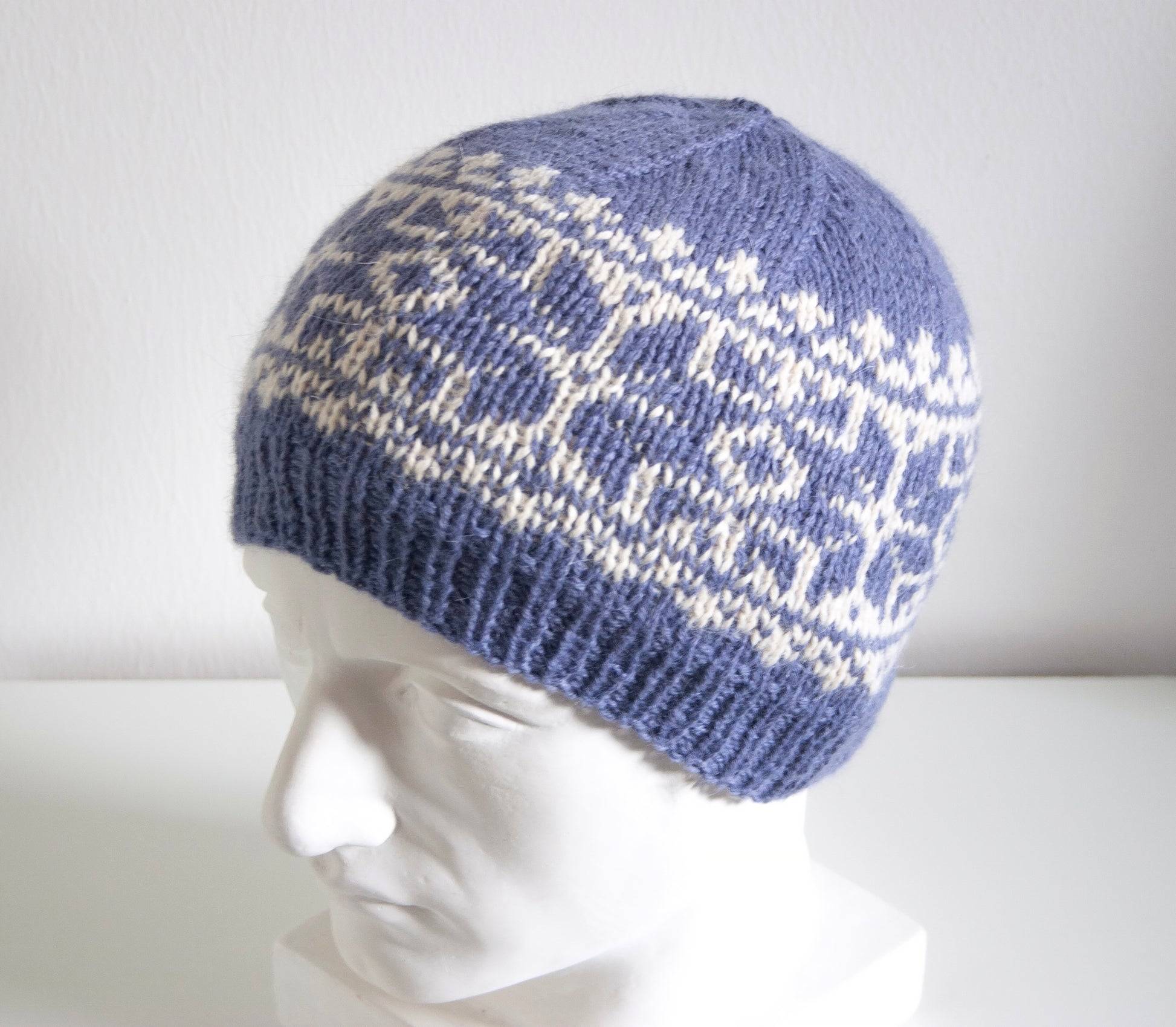 blue and white alpaca wool hand-knitted Fair Isle beanie hat in snowflake knitting pattern