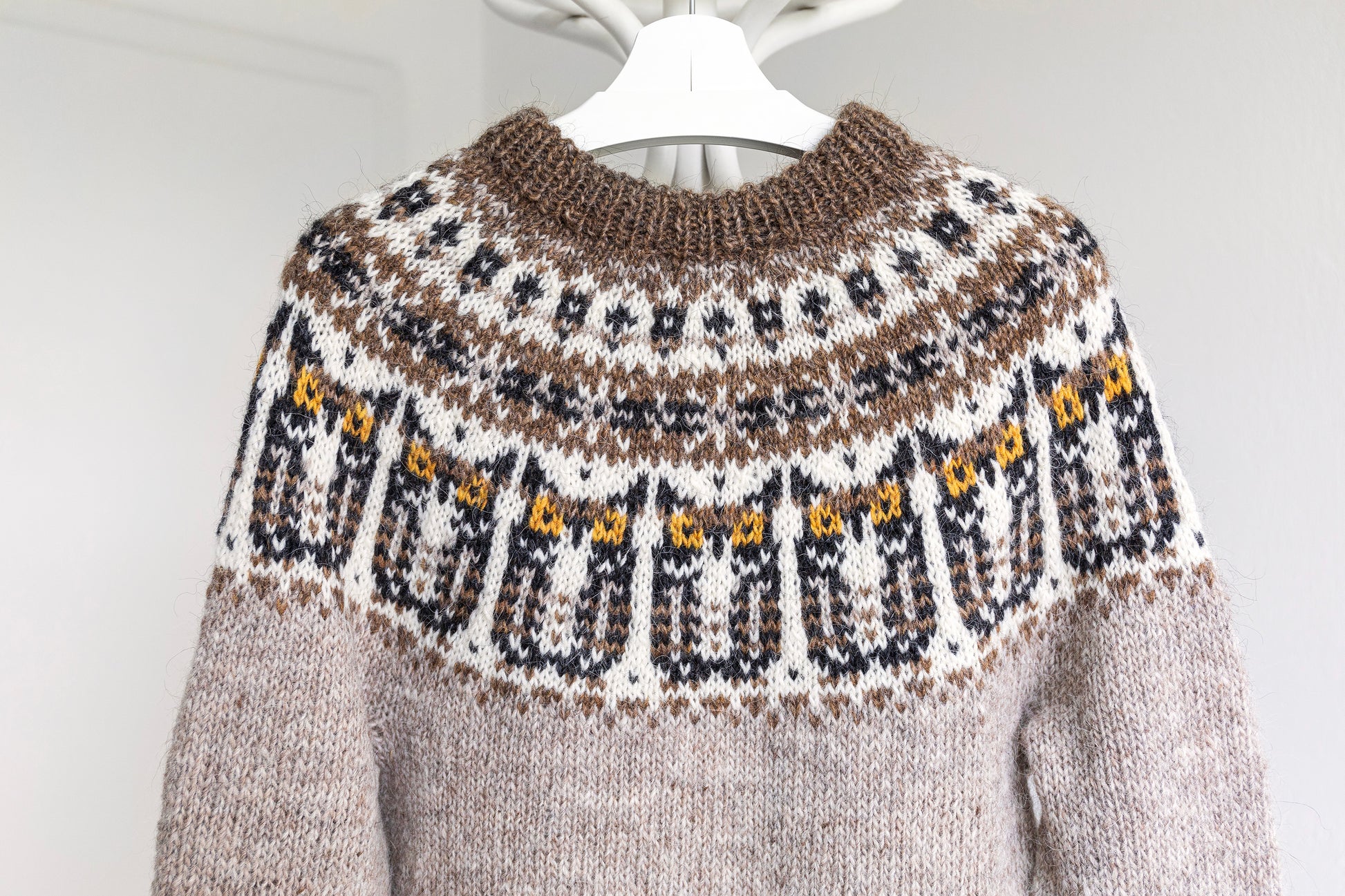 Close-up of a icelandic lopapeysa yoke features eagle-owl motifs