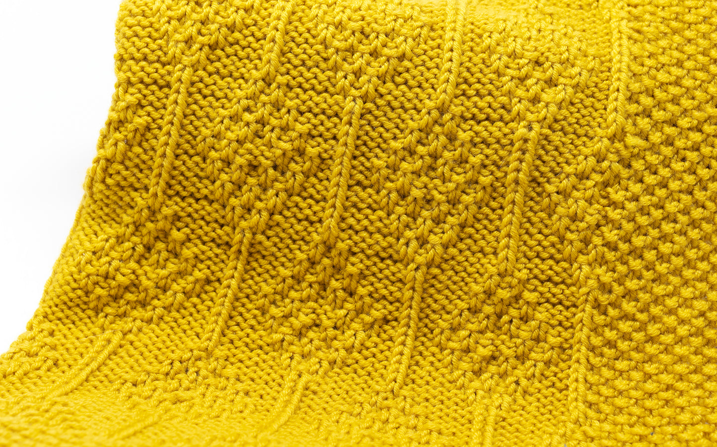 texture of mustard yellow merino wool hand-knitted baby blanket in Diamonds pattern