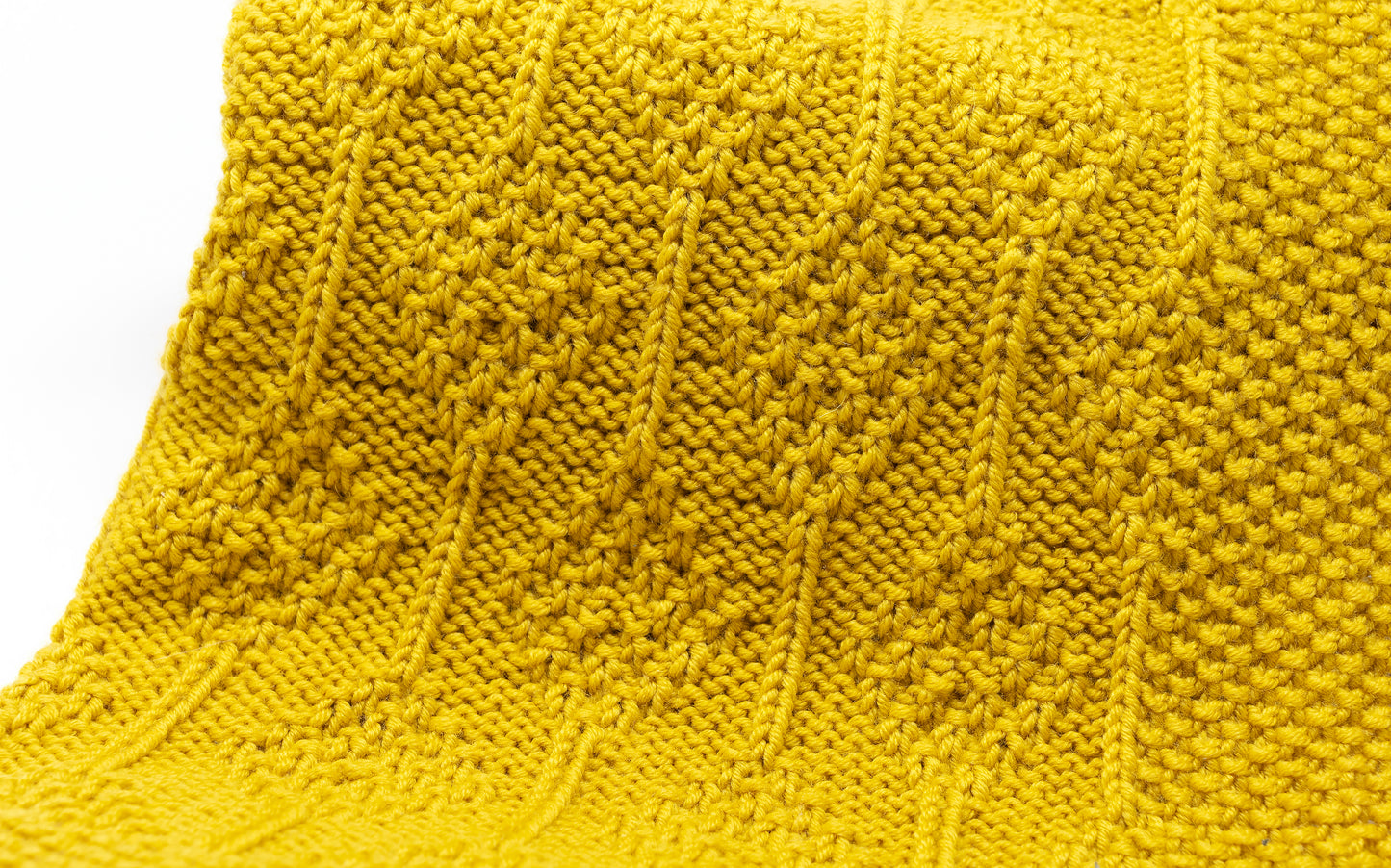 Close up for Yellow superwash merino wool DK yarn hand-knitted baby blanket in Diamonds knitting pattern