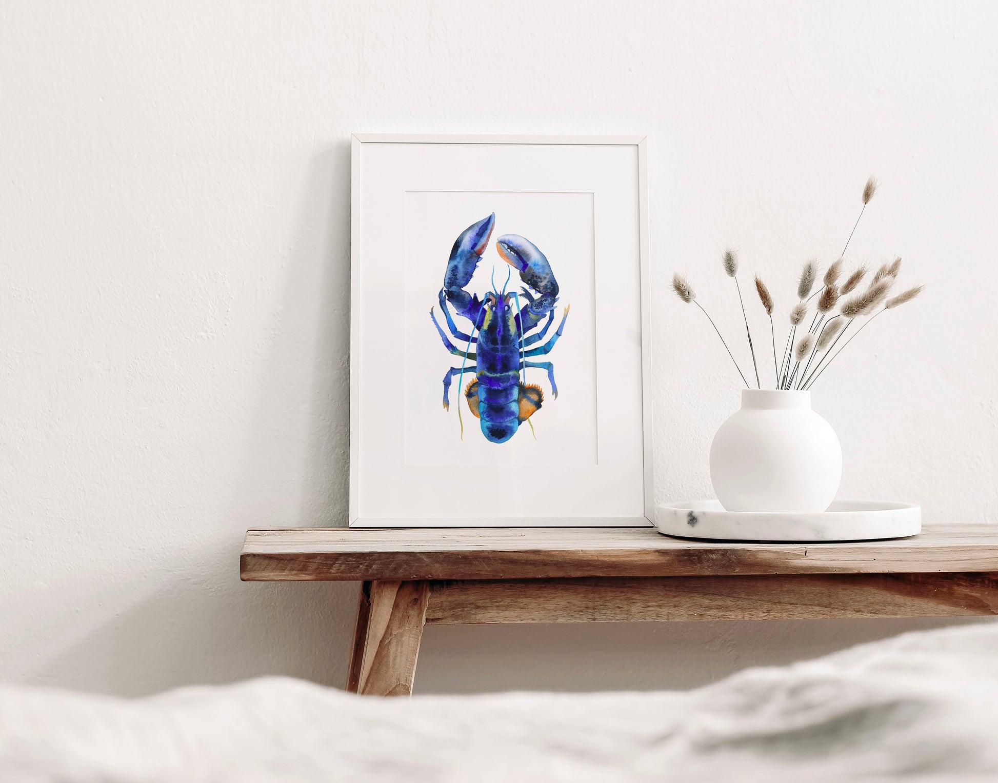 Small blue lobster watercolor art print on a wooden table