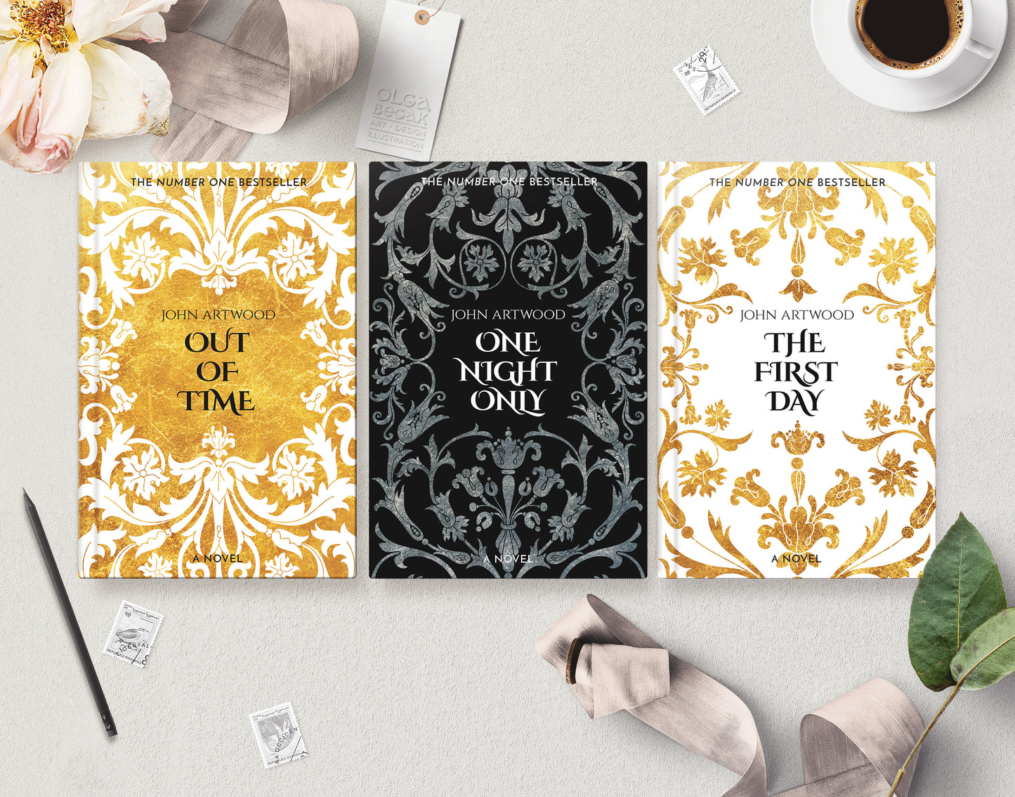 Three premade book series cover templates are arranged in a styled flat lay on a light gray surface, surrounded by decorative props including a coffee cup, flowers, stamps, a pen, and ribbons.