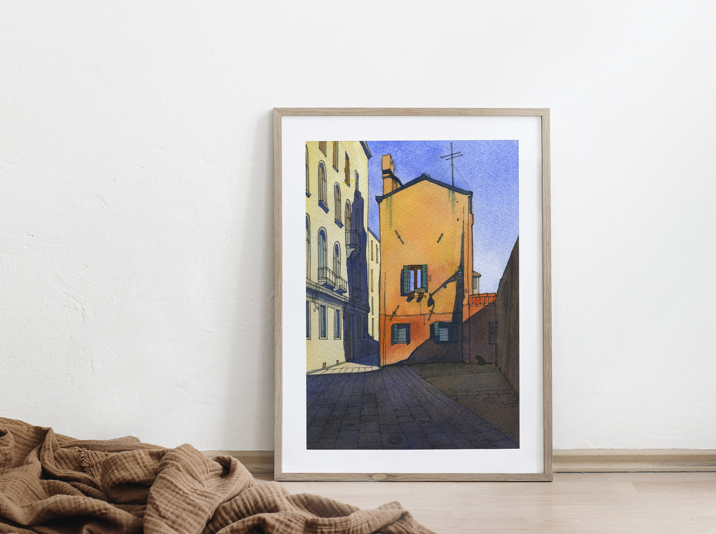 Large framed watercolor and ink artwork of Calle Pesaro in Cannaregio, Venice on a white wall with a textured brown blanket.