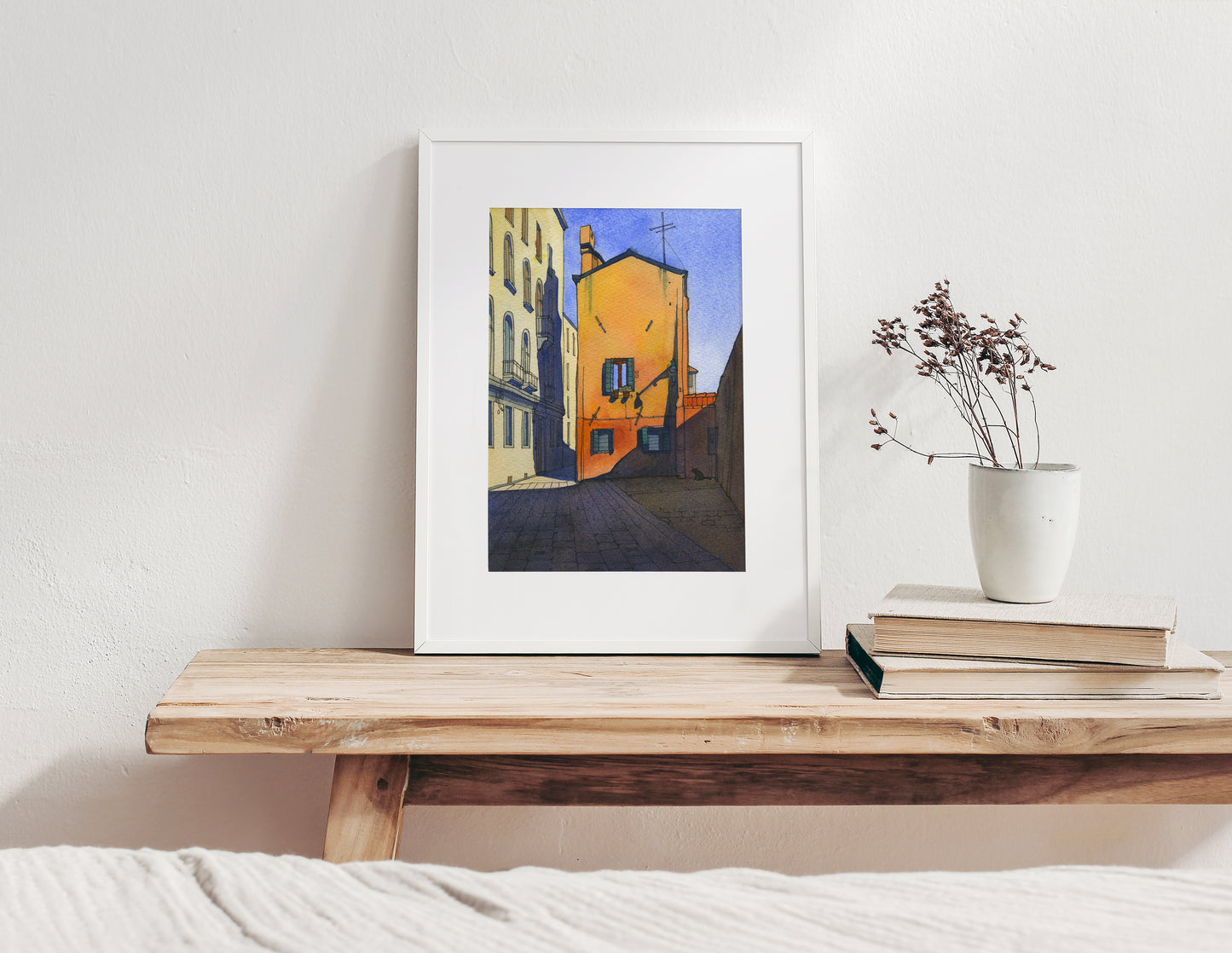 Framed watercolor and ink artwork of Calle Pesaro in Cannaregio, Venice, on a wooden table.