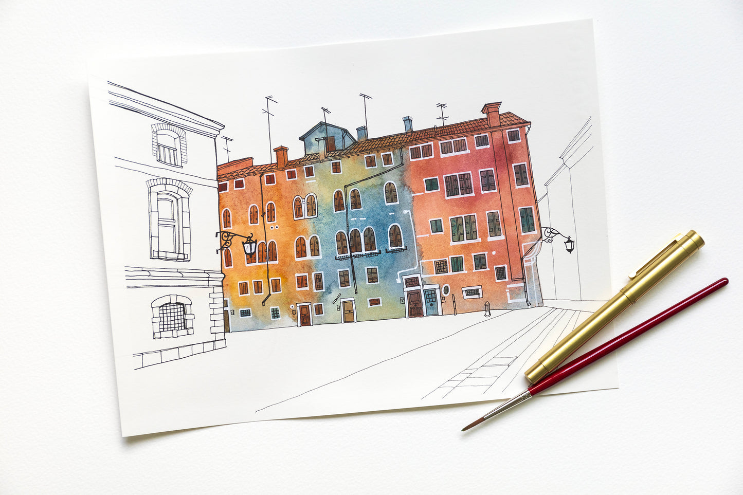 Original watercolor and ink artwork of Venetian Campo San Geremia, accompanied by a pen and brush.