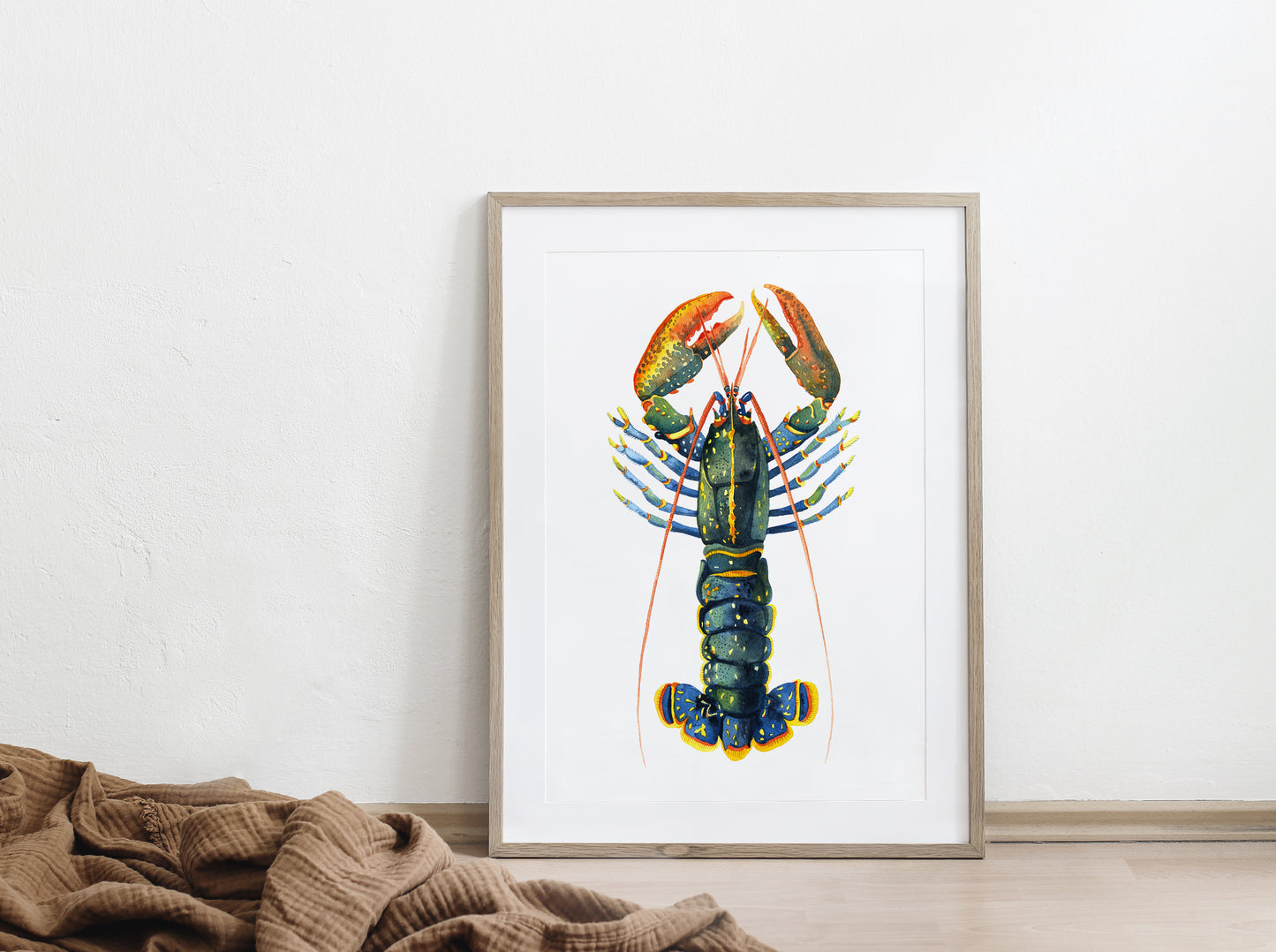 Framed european lobster watercolor art print, displayed on a floor