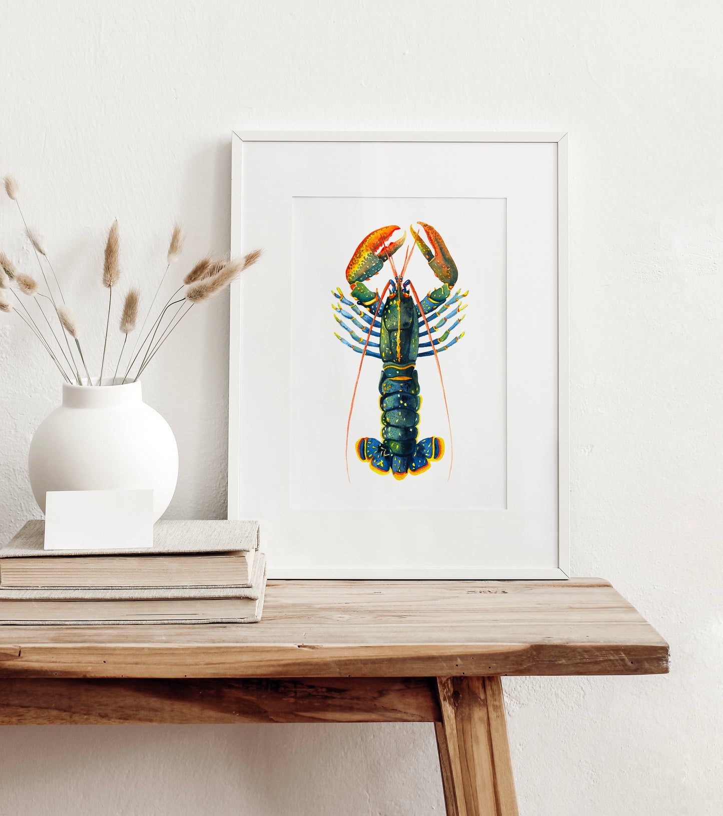 Framed european lobster watercolor art print on a wooden table