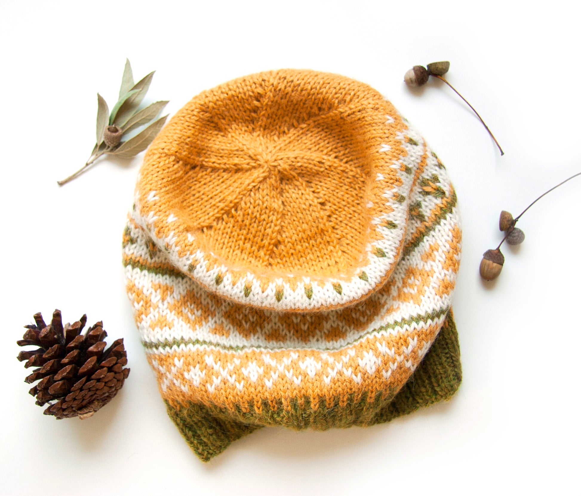A crown of a Fair Isle hand-knitted alpaca hat in yellow, white, and green.