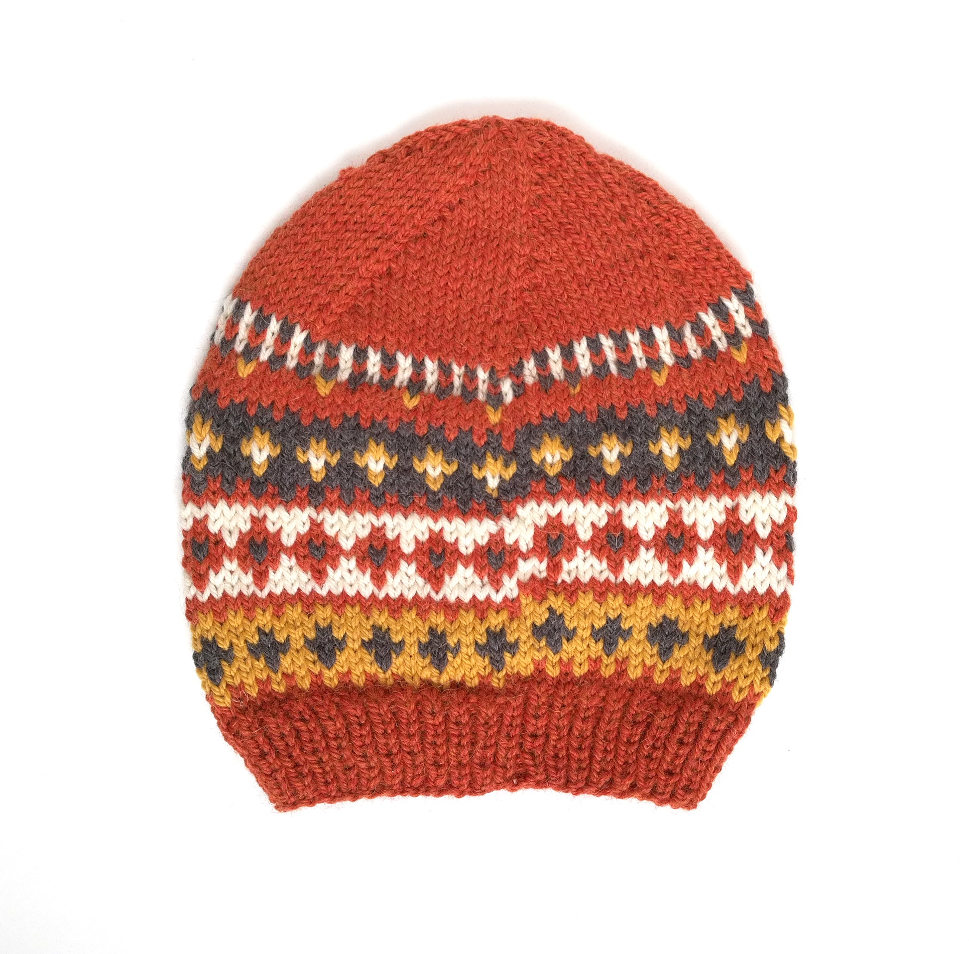 Back side of a hand-knitted Fair Isle style hat made of wool and alpaca yarn, with an orange and multicolored geometric pattern