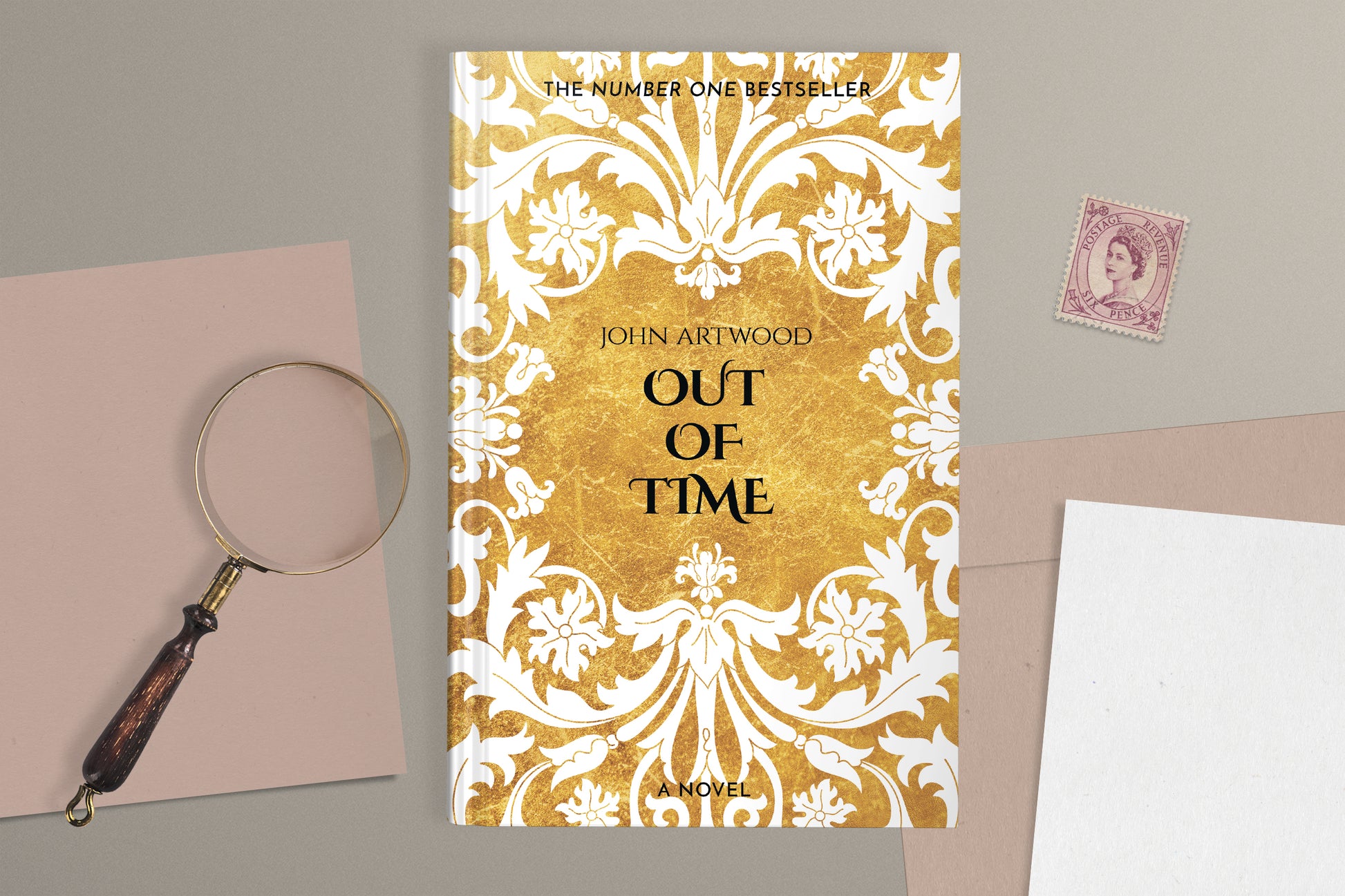 A hardcover book featuring white baroque ornament of a gold background, displaying on a gray surface