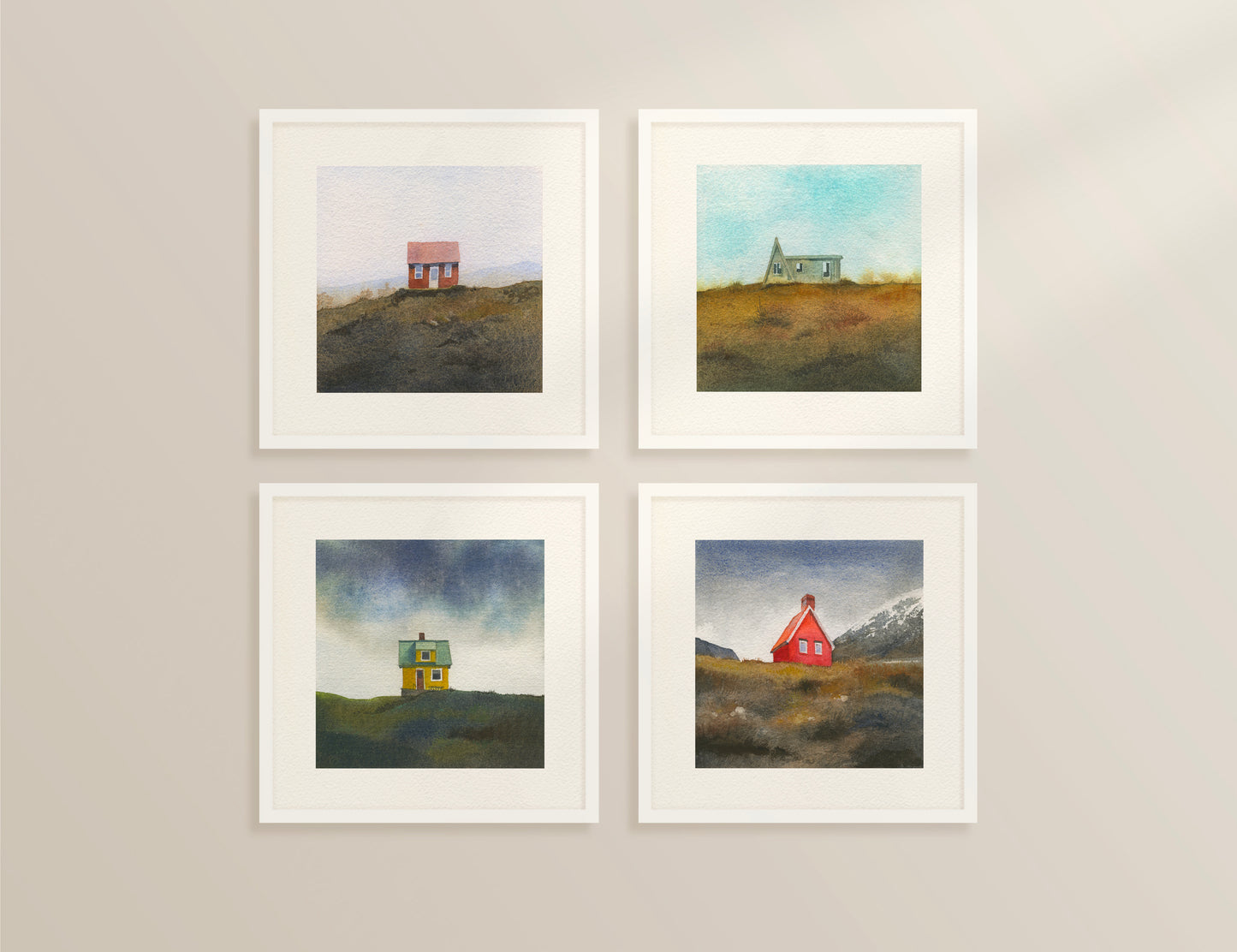 Four framed watercolor Icelandic landscapes — an A-frame cabin in the Westfjords, a red cottage in the Icelandic hills, a red cabin near Egilsstaðir in East Iceland, and a colourful house on Flatey Island.