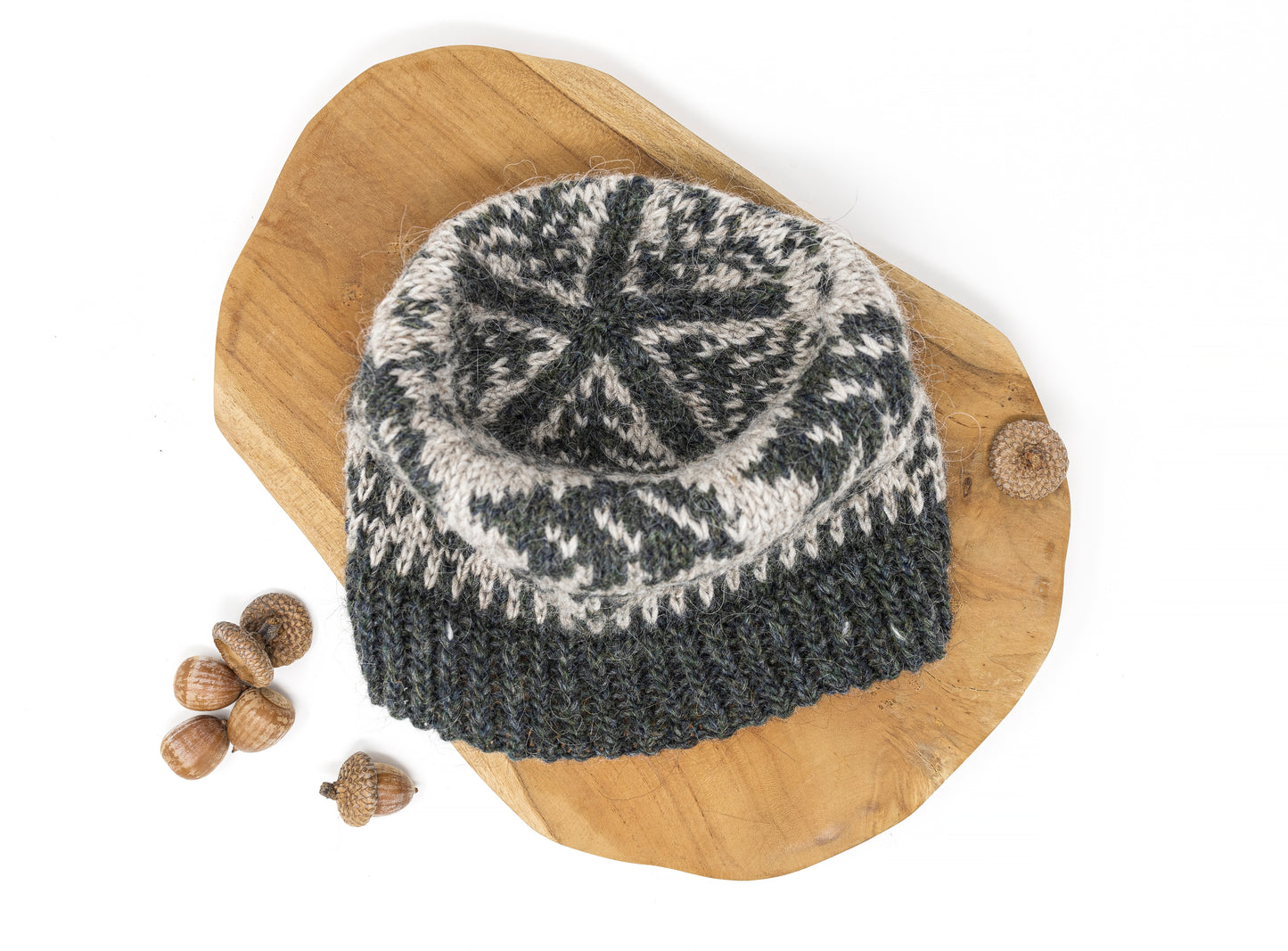 A crown of a beanie hat with a dark gray-green and light beige Fair Isle style pattern, featuring bears.