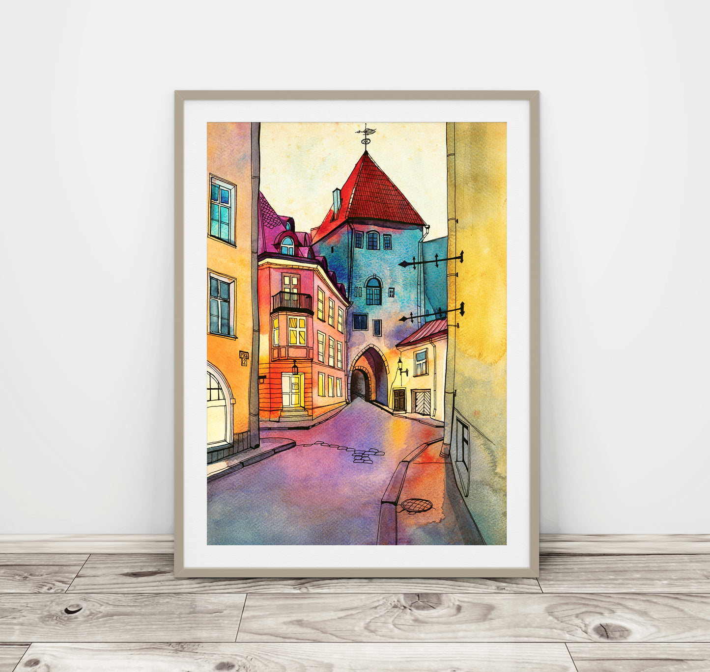 A framed watercolor and ink artwork featuring a colorful view of Pikk Street in Tallinn, Estonia, presented in a wooden frame.