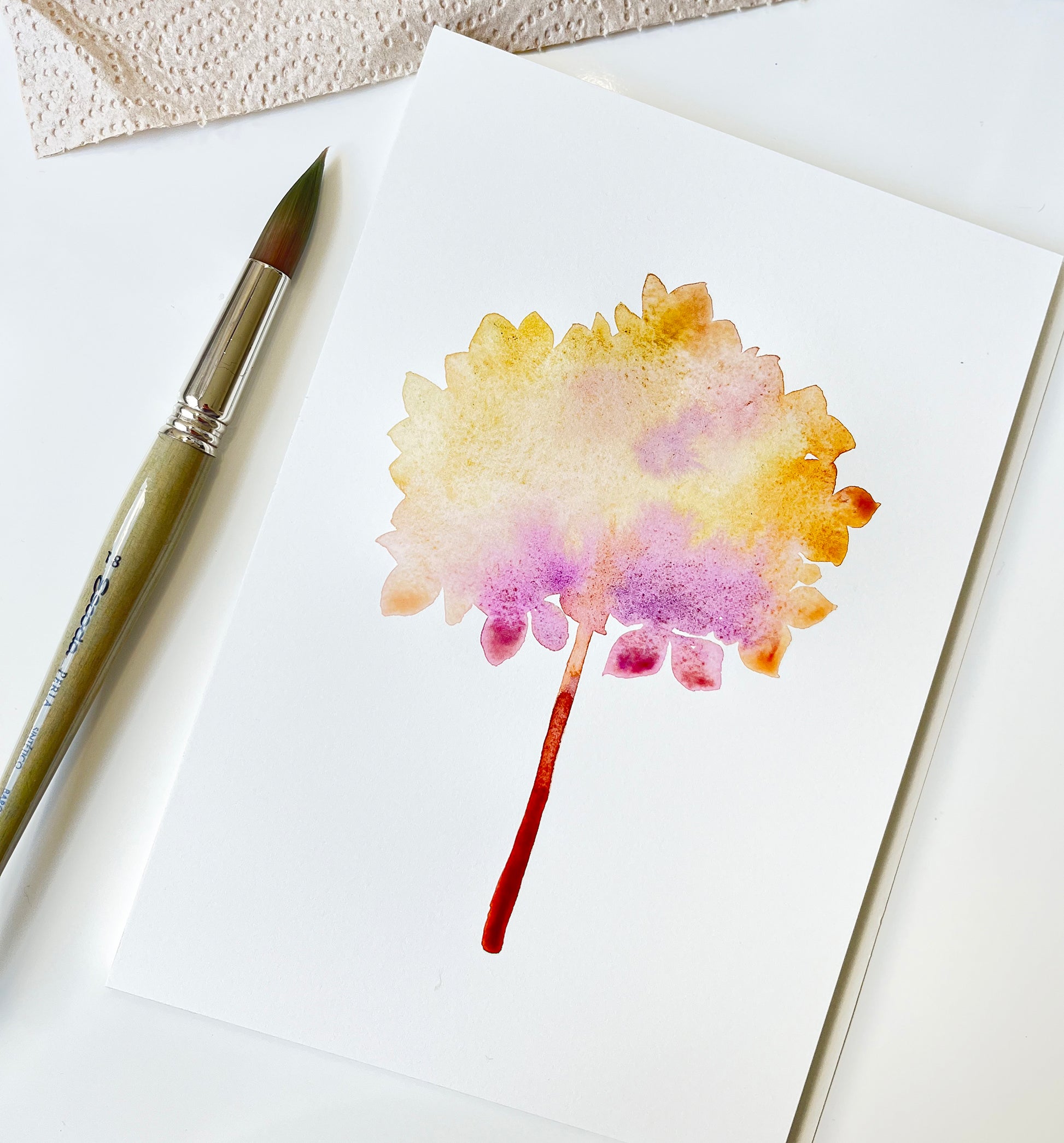 Pink hydrangea dried flower ball watercolor painting in progress, accompanied by paintbrush
