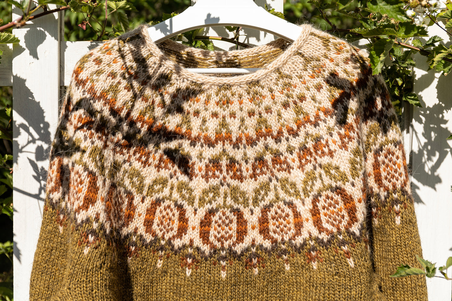 Pomegranate Icelandic lopapeysa sweater styled outdoors on a fence