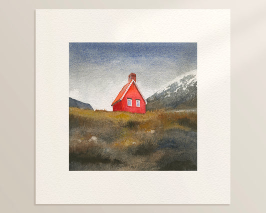 A square watercolor painting featuring Red Cabin near Egilsstaðir, known locally as the Red Cabin of Fagridalur, stands along the road through East Iceland, framed by golden grass and distant snow-capped peaks.