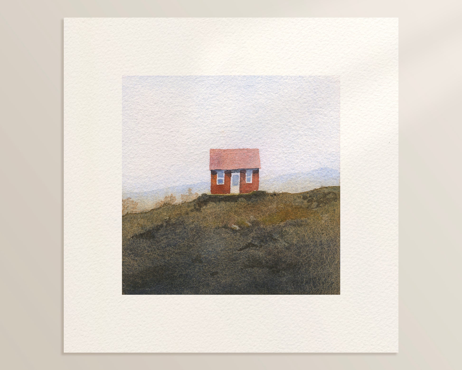 A square watercolor painting features a small red cabin, known locally as Ásgarður, sits among the hazy hills of rural Iceland.