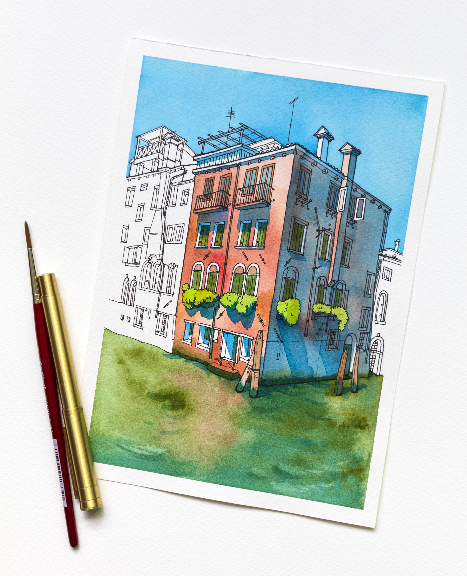Original watercolor and ink artwork of a historical building on Rio della Misericordia in Venice, and art supplies on a white background