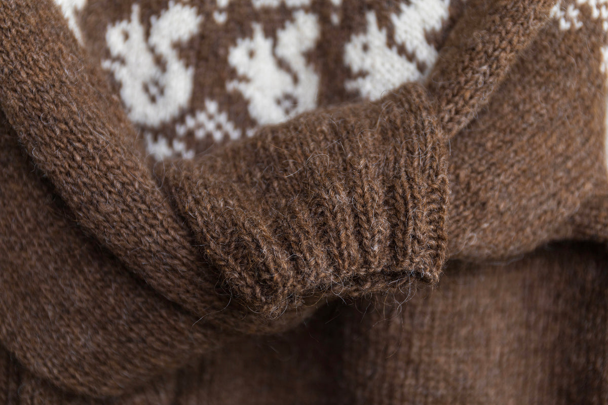 close up for ribbed cuffs of a brown and white hand-knitted sweater
