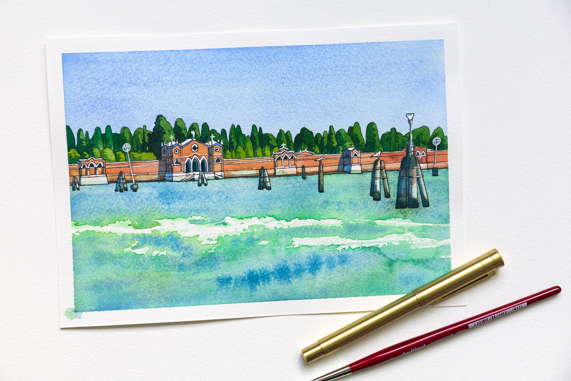 Original watercolor and ink artwork of San Michele island in Venice accompanied by two pens
